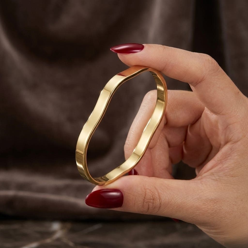 A luxurious bracelet in elegant gold, featuring a unique, flowing, and polished wave design. It adds a touch of modern luxury to your look. An attractive design for any occasion. Women's Bangles (5)