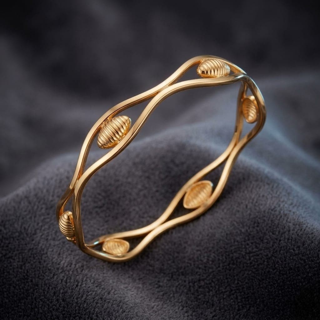 A luxurious bracelet in elegant gold, with a flowing wavy design interspersed with attractive ribbed oval pieces, adding a touch of modern luxury to your look. Women's Bangles (5)