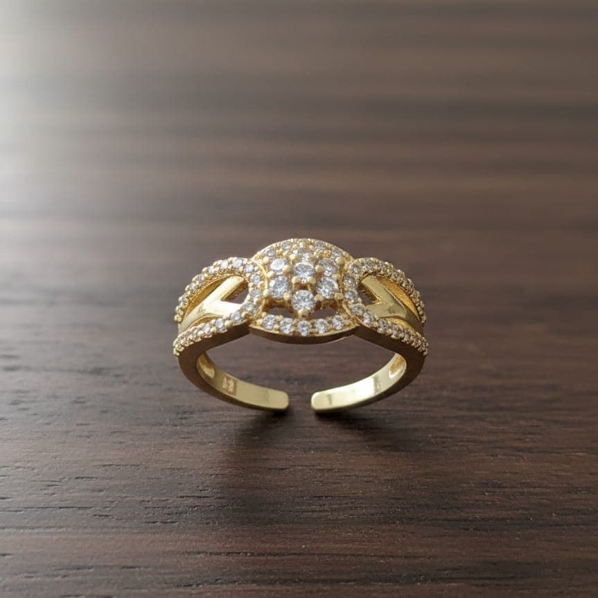 A luxurious gold ring adorned with sparkling zircon stones in the middle and on the sides, with an open, adjustable design to ensure a perfect fit and comfort for all sizes. Women's Rings (5)