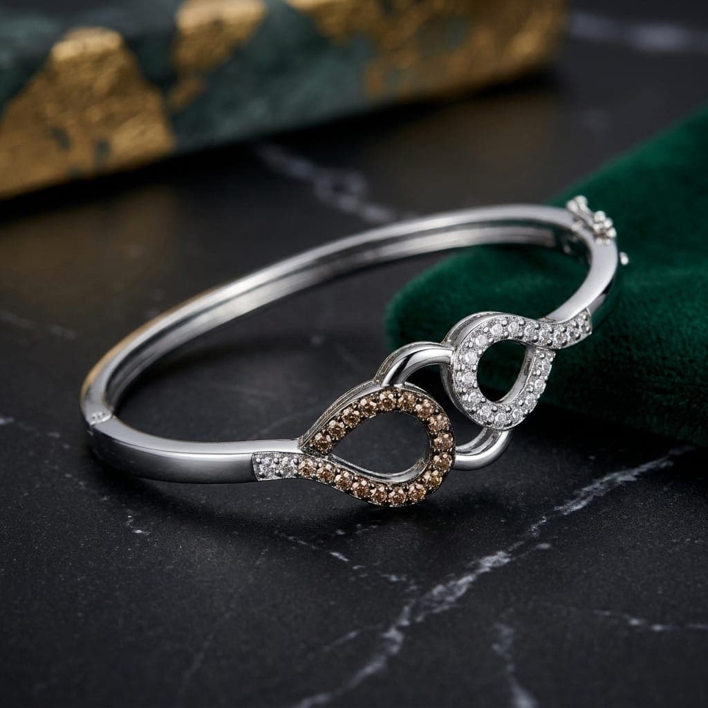 A luxurious bracelet in elegant silver, with an interlocking design studded with delicate zircon stones and others in shiny brown, with a modern side clasp for an eye-catching everyday look. Women's Bangles (5)