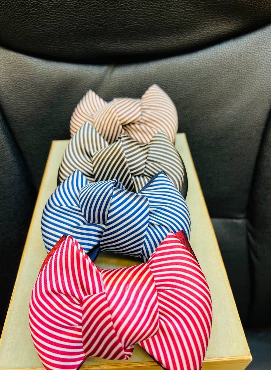 "Beige and white striped bow hair clip, an elegant touch that adds femininity and distinction to your look."