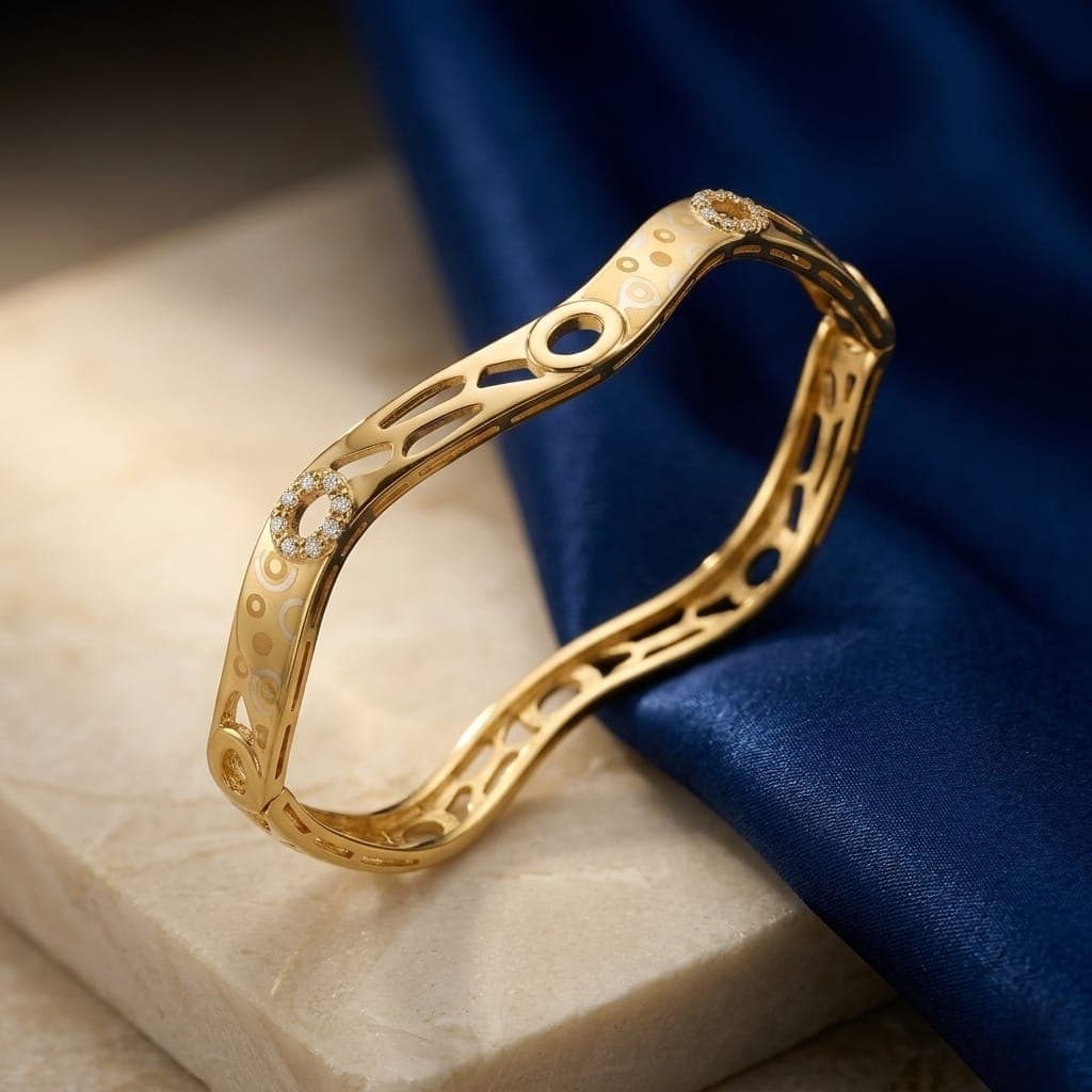 An elegant gold-colored bracelet with an innovative wavy, streamlined design, adorned with oval cutouts and rings studded with charming zircon stones, giving you a luxurious, modern look. Women's Bangles (٦)