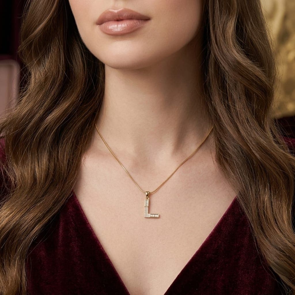A luxurious, elegant gold necklace with a sumptuous L pendant studded with sparkling baguette and zircon stones, and an adjustable clasp to fit you. (3)