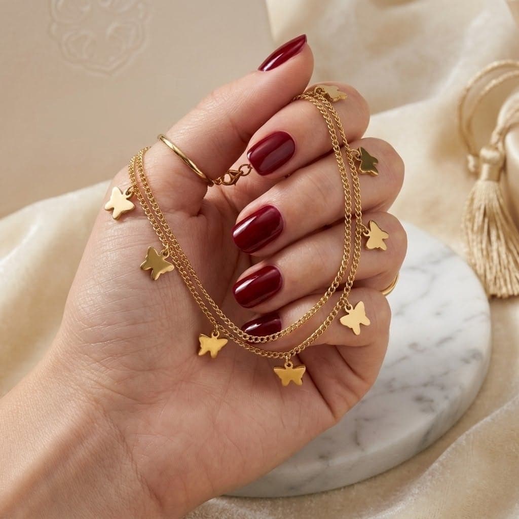 A luxurious anklet in elegant gold, with a double-layered design and decorated with soft dangling butterflies that add charm to your look, with an adjustable clasp to fit you. (٤)