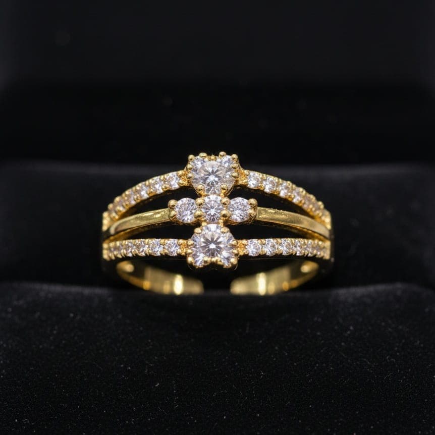 A luxurious gold ring with an innovative three-row design adorned with sparkling stones, featuring a small heart-shaped top and bottom stone. Open to fit all sizes. Women's Rings (٥)