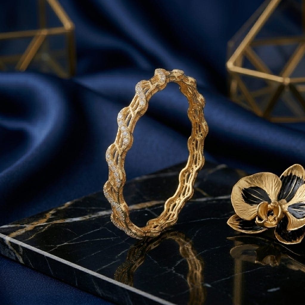 An elegant gold-tone bracelet with a flowing, wavy design that blends luxury and simplicity. Adorned with sparkling zircon stones and delicate engravings, it adds a touch of beauty to your look. Women's Bangles (6)